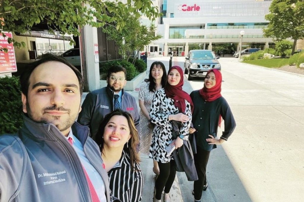 Internal medicine residents outside hospital entrance.